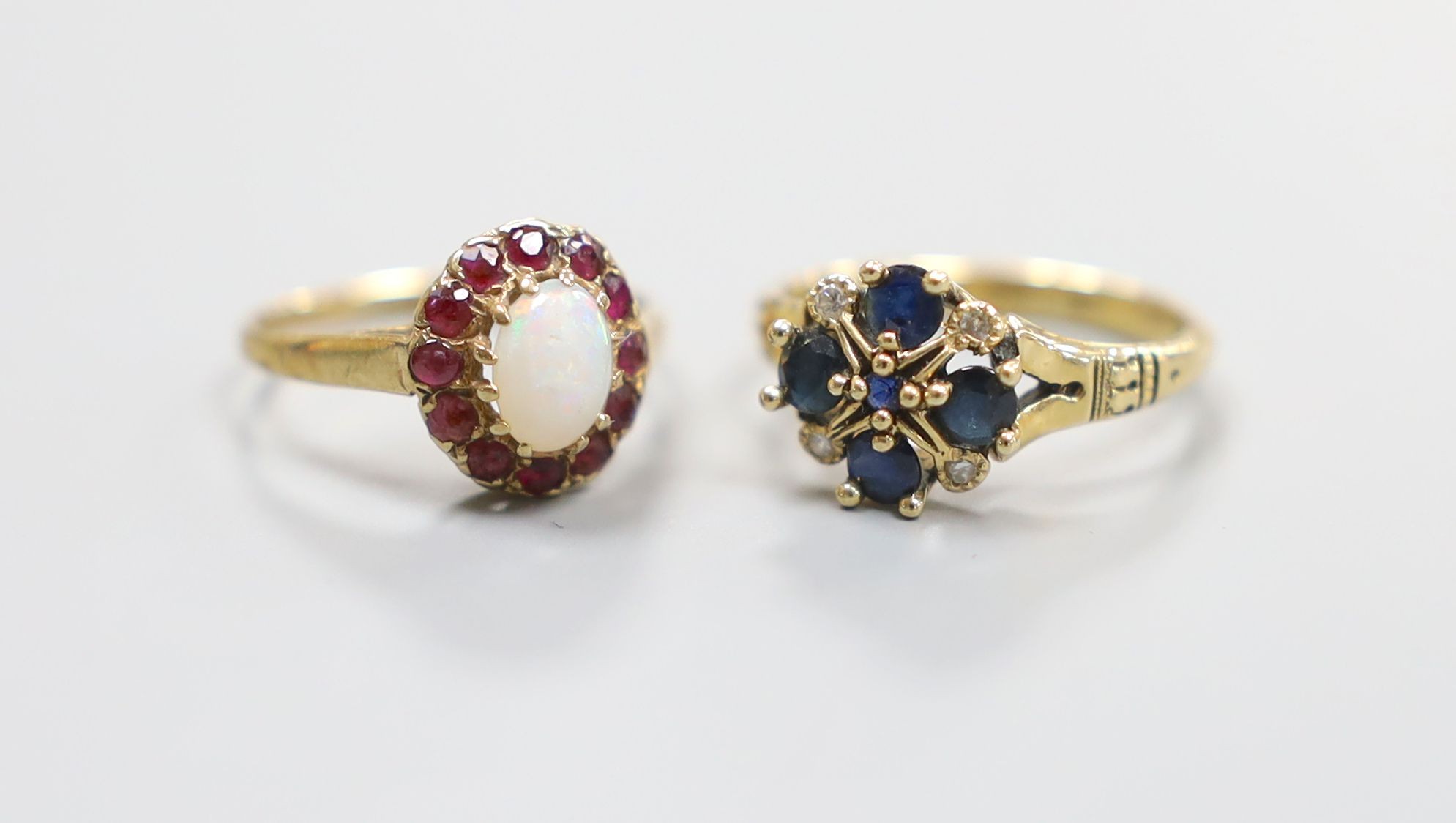 A modern 14ct gold, sapphire and diamond set cluster ring, size L, gross 3.2 grams and a 9ct gold opal and ruby cluster ring, size L, gross 1.6 rams.